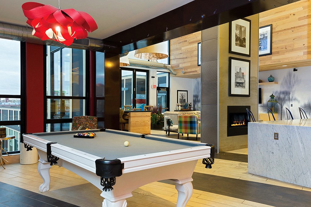 a pool table in a living room with a fireplace a pool table in a living room with a fireplace at Ann Arbor City Club, Ann Arbor